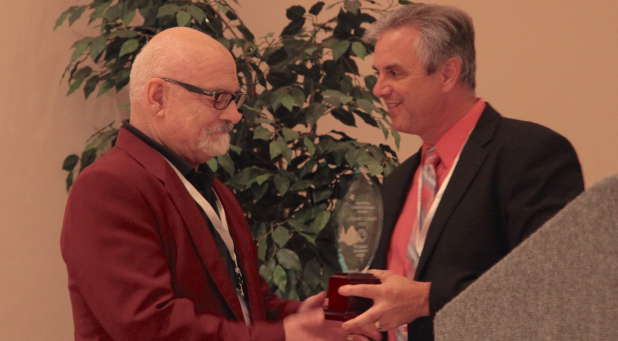 Ken Archer, new SPS president (right), presents the Lifetime Achievement Award to Frank Macchia, Vanguard University professor and 'Pneuma' editor.