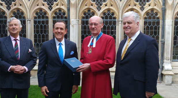 The Dean of Windsor David Connor accepts the special Bible for Queen Elizabeth II from Charisma Media CEO Steve Strang, left, at Windsor Castle in England on May 8.